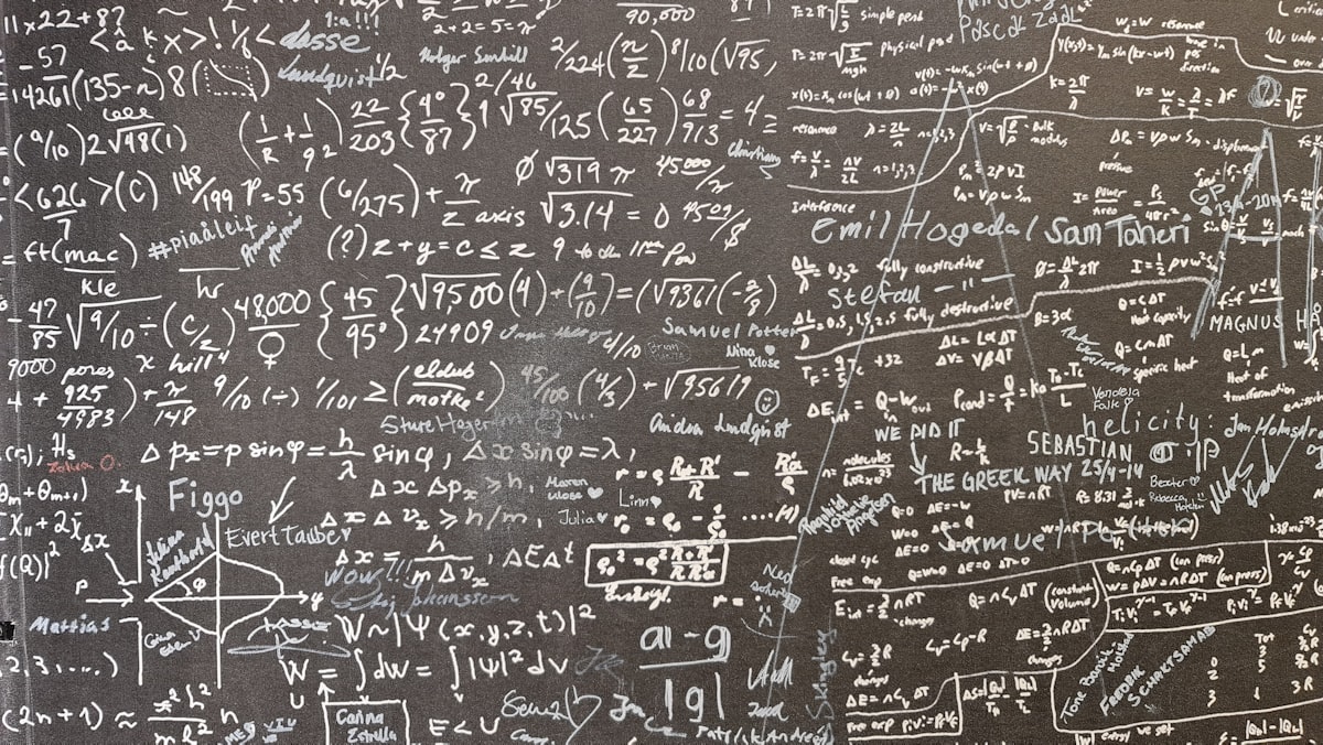 A chalkboard covered in dense handwritten equations