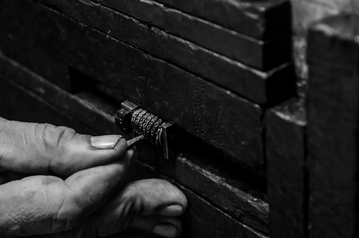 Hands picking a lock mechanism, in black and white